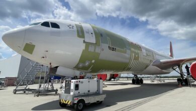 Closeup view of a large jet with patches on its fuselage where technicians have installed new sections to change the plane into a freighter.