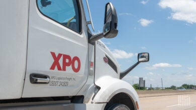 A closeup of a white XPO daycab on a highway