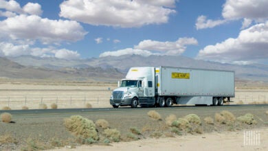 A white JB Hunt sleeper cab pulling a white JB Hunt dry van trailer on a highway