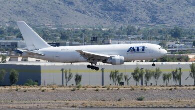 A white ATI cargo jet seen about to land at a desert airport.