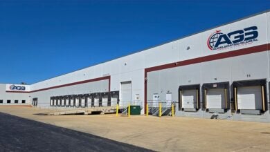 An AGS warehouse with multiple truck doors on a clear day.