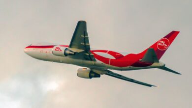 A red-and-white jetliner takes off into the clouds.