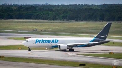 A Prime Air cargo jet with light blue and dark blue logo rolls to the runway.