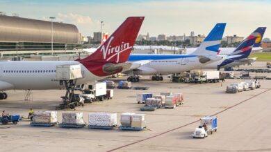 Virgin Atlantic and other passenger jets parked at their gates as vehicles move baggage and cargo carts to the loading bays.