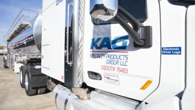 A white KAG tractor with a tank trailer