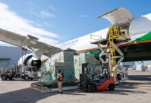 A cargo jet onboards a pallet of cargo and jet fuel from a tanker truck.