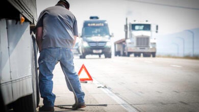 Truck driver with truck on shoulder