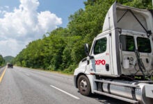 A white XPO daycab on a highway