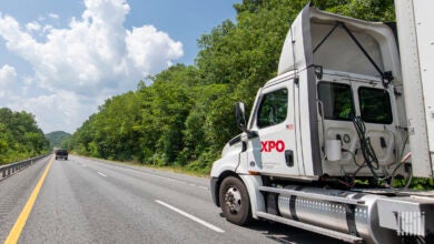 A white XPO daycab on a highway