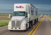 A FedEx Freight tractor pulling two pup trailers on a highway