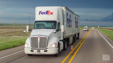 A FedEx Freight tractor pulling two pup trailers on a highway