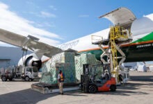 Cargo is ready to be loaded on a large aircraft using a hydraulic lift.