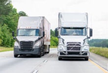 Front view of two tractor-trailers on a highway