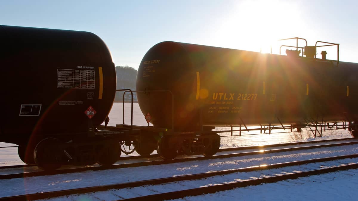 Two oil tanker railroad cars on a railroad track.