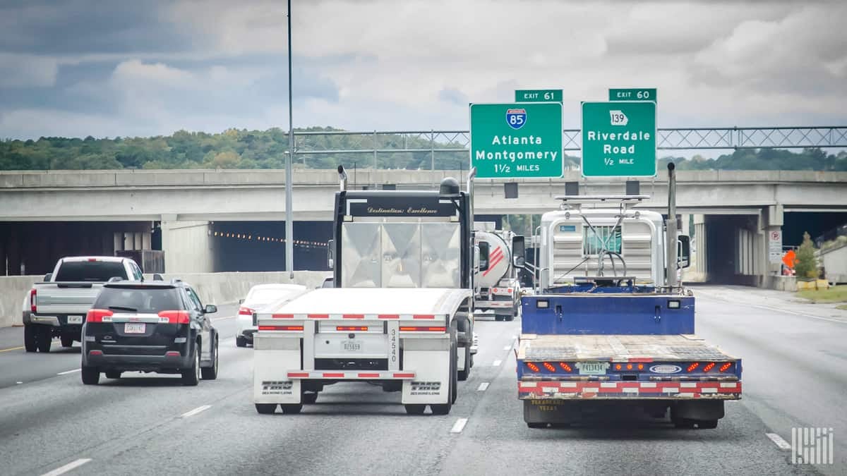 two trucks travel down a highway