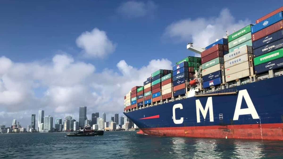 A cargo ship docked at PortMiami with the City of Miami in the background.