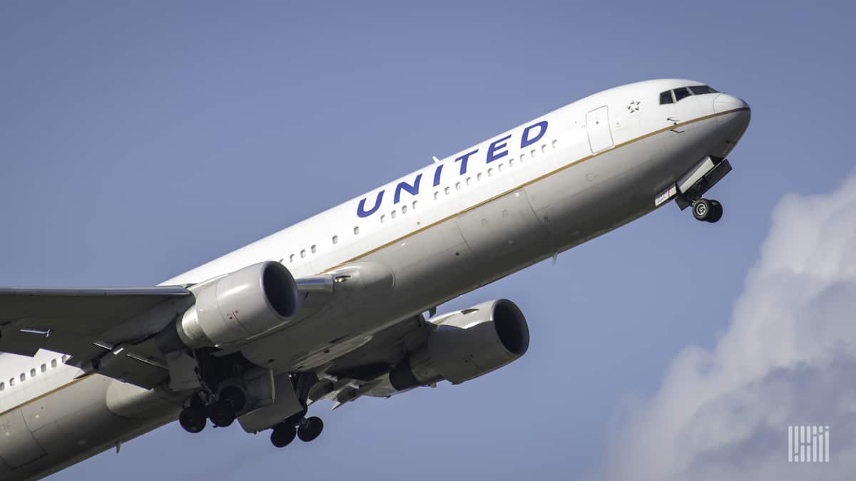 A white United Airlines plane takes off , view from behind.
