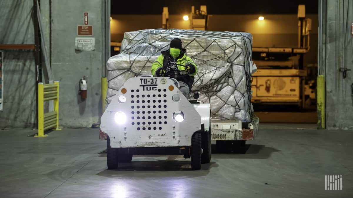 A tractor pulls a cargo pallet.