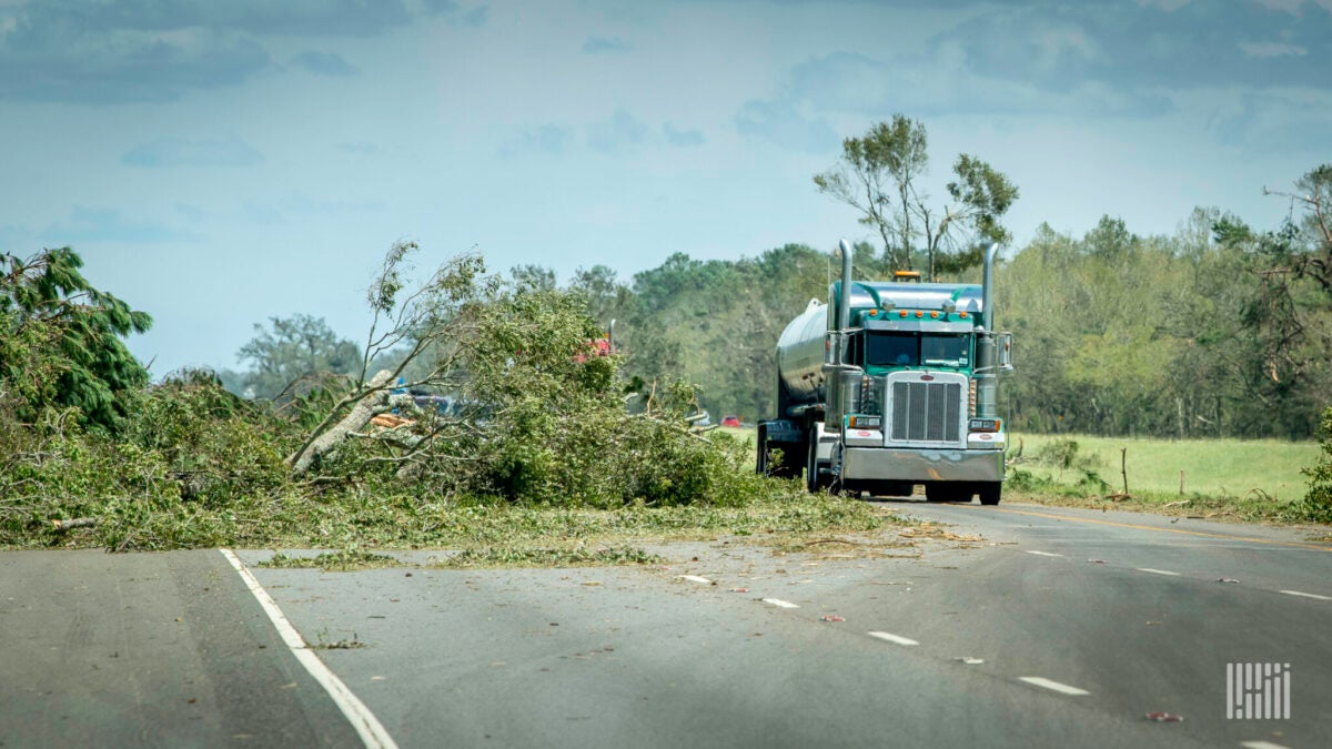 Tractor-trailer goes around fallen trees. 
(Photo: Jim Allen/FreightWaves)