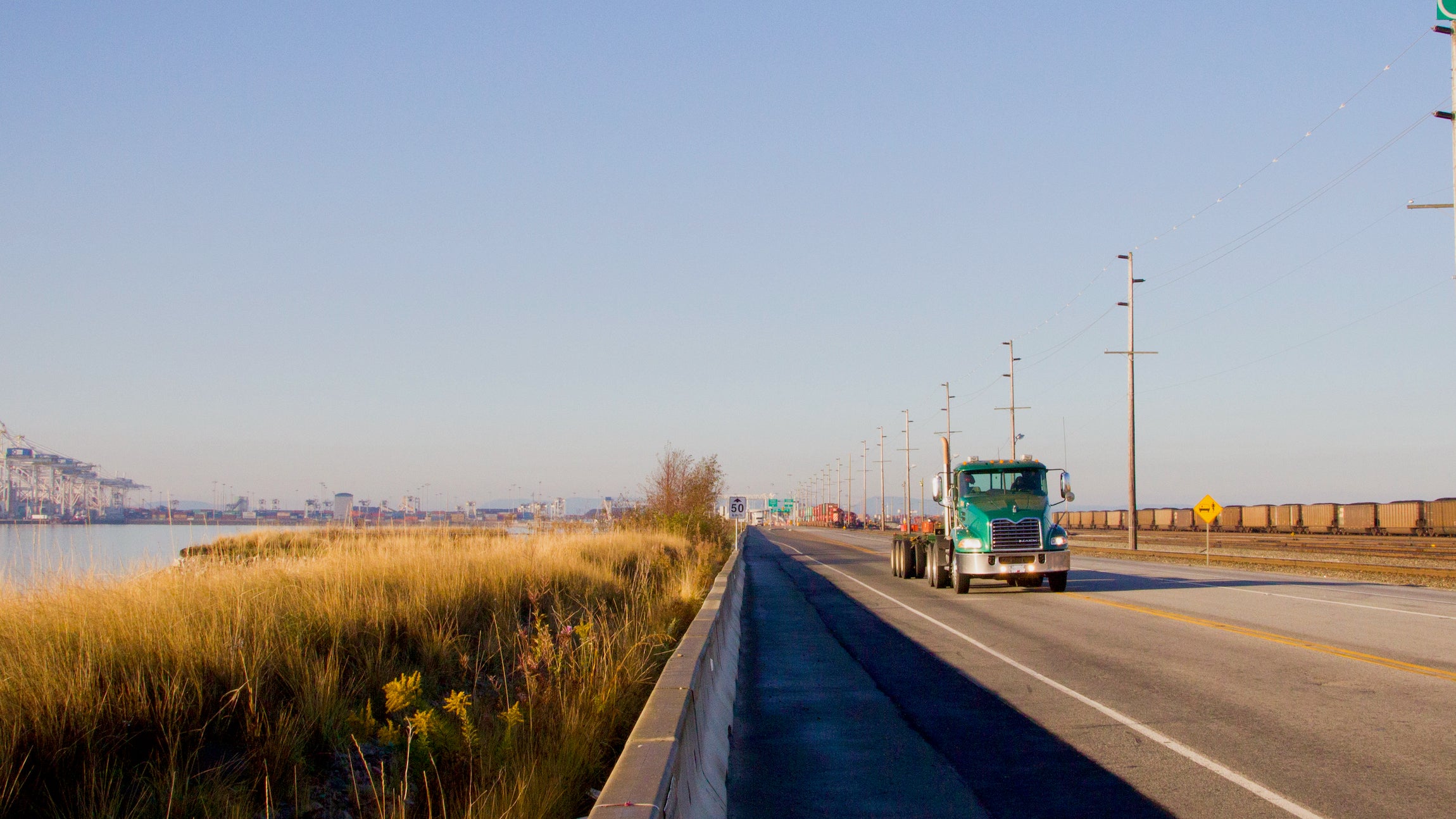 A truck outside the Port of Vancouver travels on a highway near the water