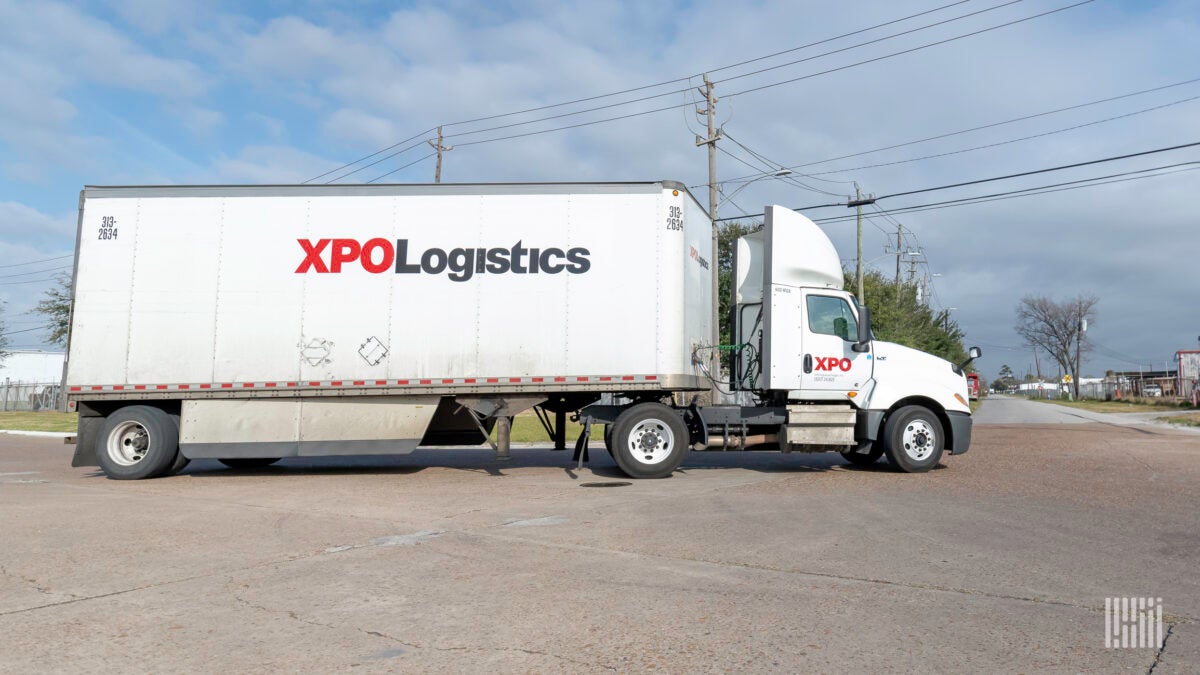 Tractor trailer with XPO Logistics logo, as seen from the side.