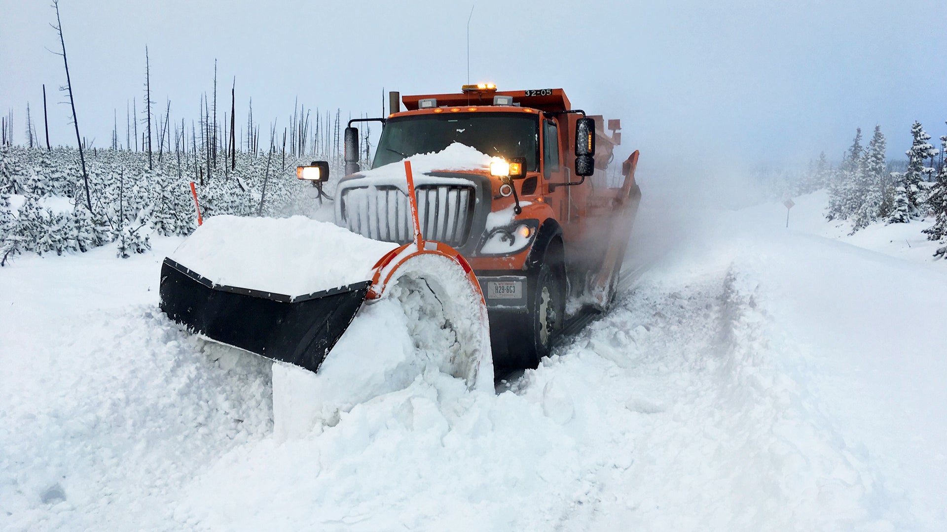 Plow truck clearing a snowy Montana highway.