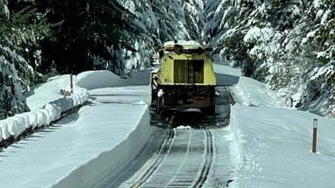 Plow truck clearing snowy road in Washington state.