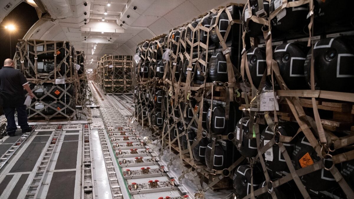 Pallets containing ammunition, explosives and other supplies are loaded onto a cargo plane.