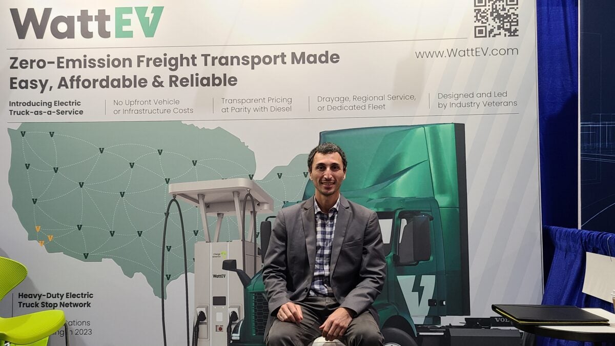 Salim Youssefzadeh, co-founder and CEO of WattEV, seated at a company display at the Advanced Clean Transportation Expo.