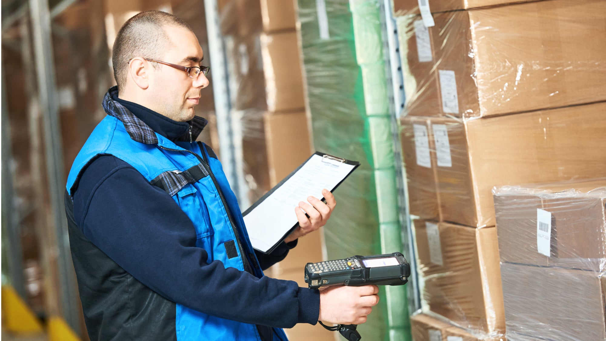 Male Worker Scanning Package With Barcode Scanner In Modern Warehouse