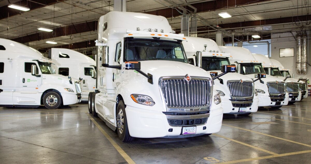 Row of white Navistar sleeper cabs retrofit with TuSimple autonomous technology.