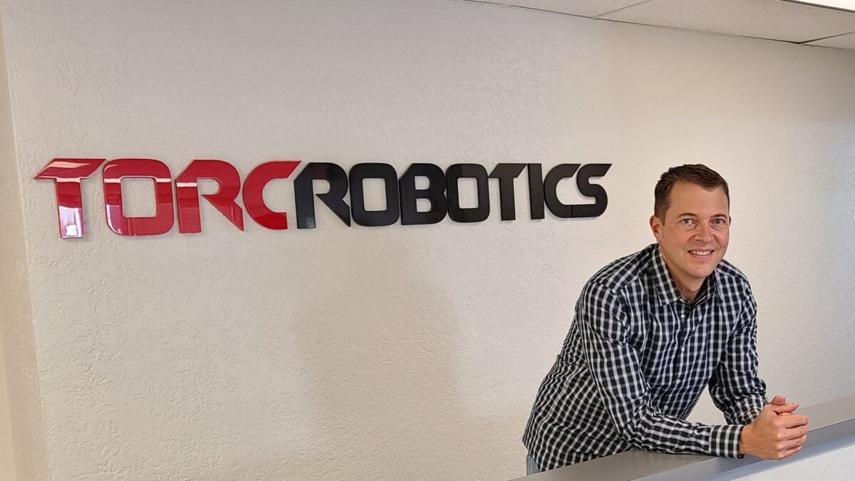 Michael Fleming in front of Torc Robotics sign