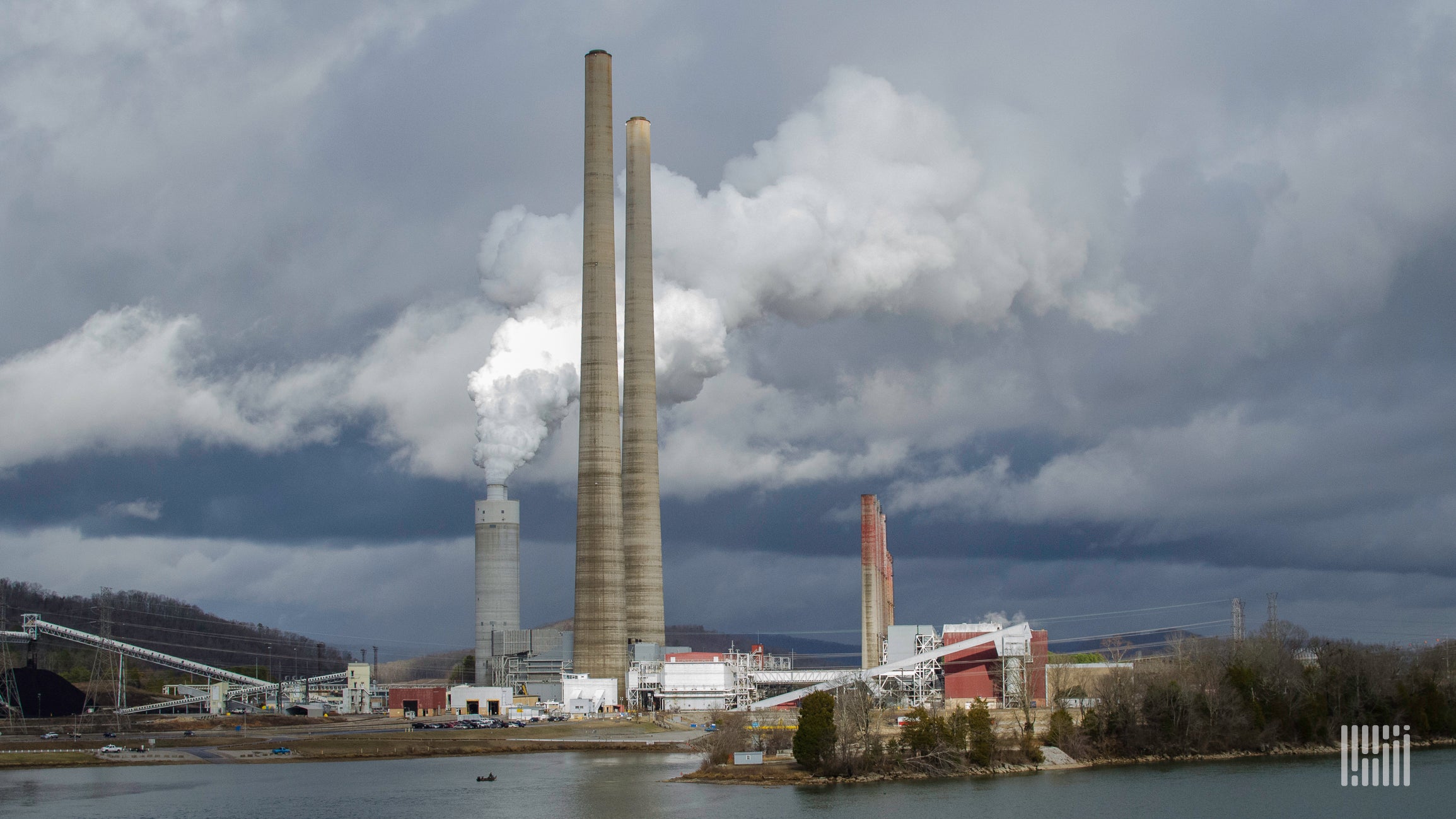 A supply chain factory has smoke emissions coming out of the factory.