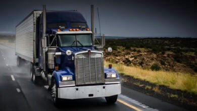 A truck rolls down the highway on a rainy day