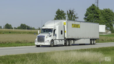 A white tractor pulling a J.B. Hunt trailer