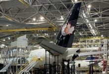 View inside a giant airplane hangar with structural work being done on the airframe.