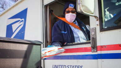 Postal service worker delivering package